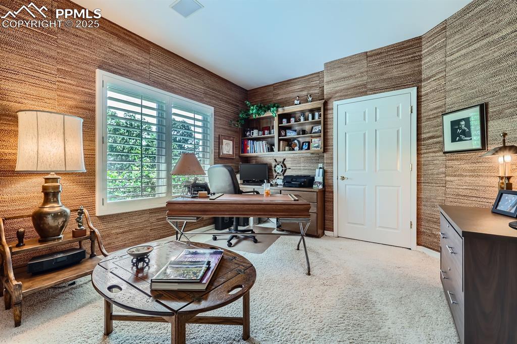 Image 9 of 49: Office off the foyer with french doors, shutters and closet