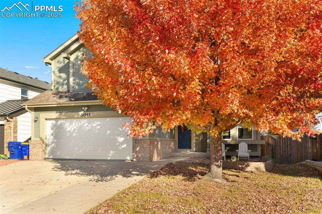 Image 10 of 34: Obstructed view of property featuring brick siding, driveway, and a garage