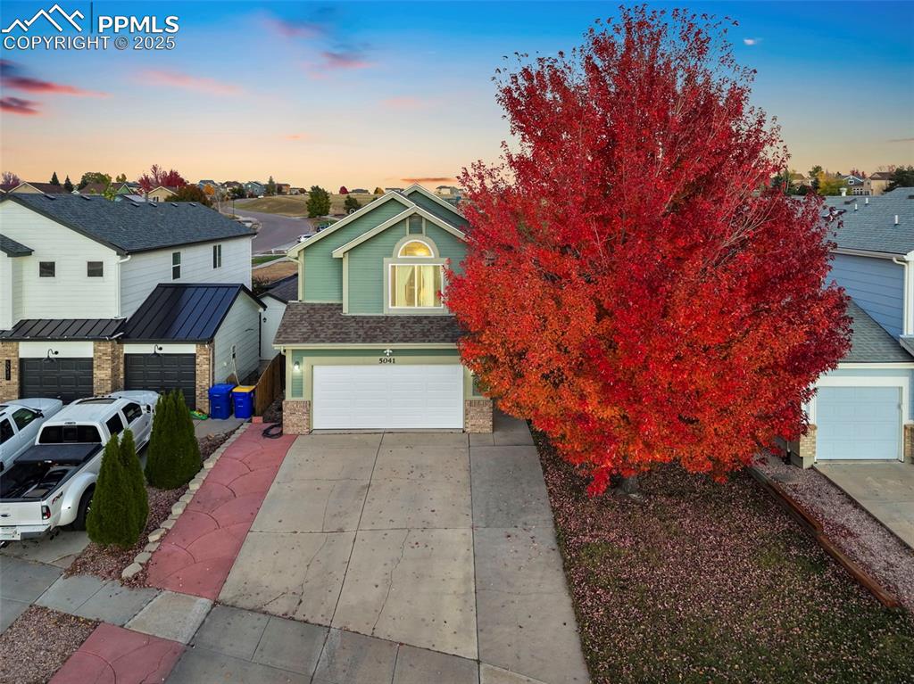 Image 2 of 34: View of front of property featuring concrete driveway, a garage, roof with