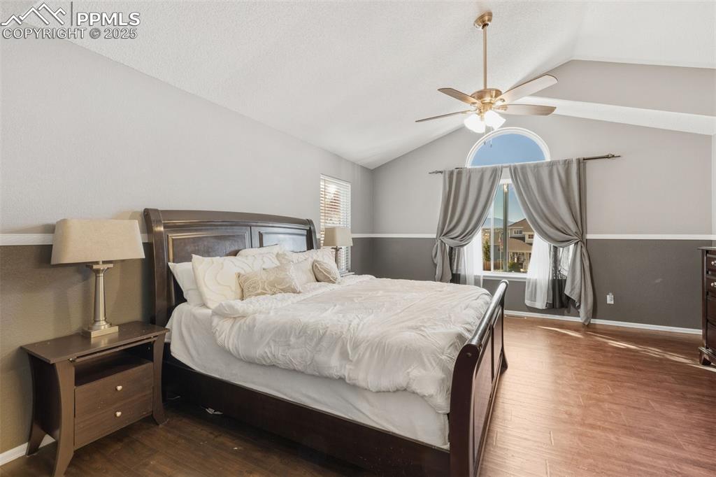 Image 23 of 34: Bedroom featuring lofted ceiling, wood finished floors, and ceiling fan
