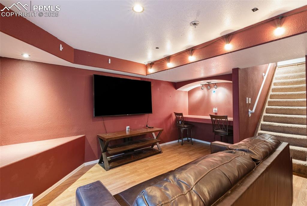 Image 30 of 34: Cinema room featuring a textured wall and light wood-type flooring