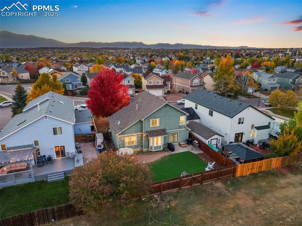 Image 5 of 34: Aerial view at dusk of a residential view and a mountain view