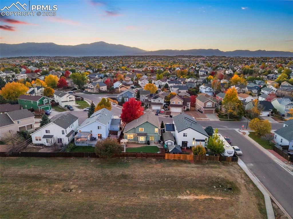 Image 7 of 34: Aerial view at dusk of a residential view and a mountain view