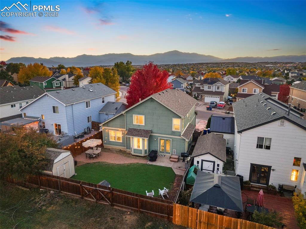 Image 8 of 34: View of front of home with a storage unit, a residential view, a patio area