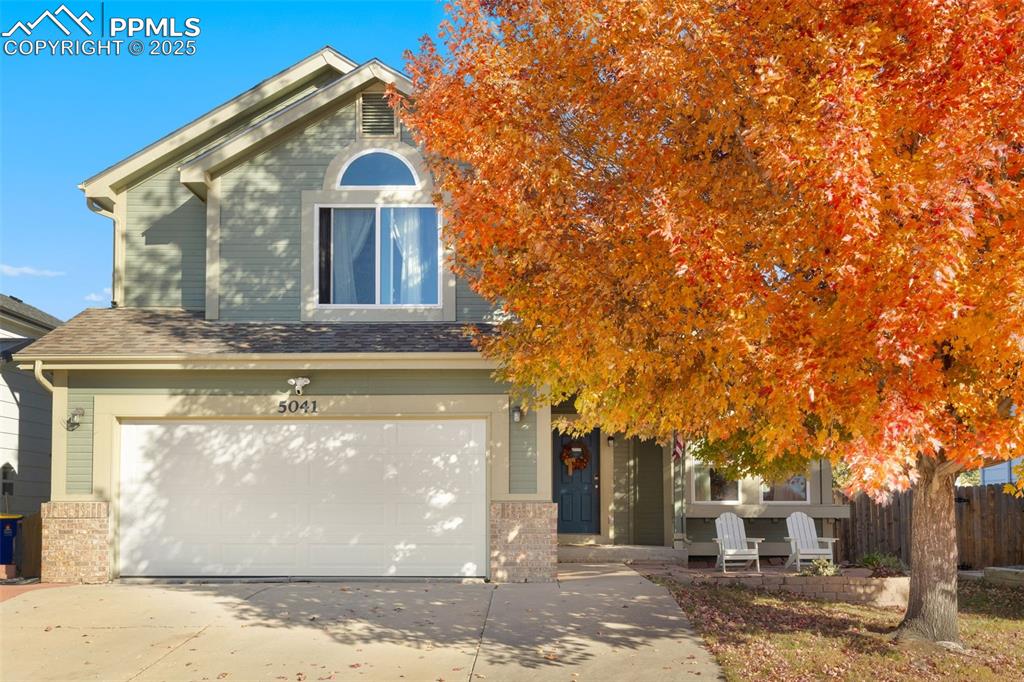 Image 9 of 34: Obstructed view of property with an attached garage, driveway, and brick si