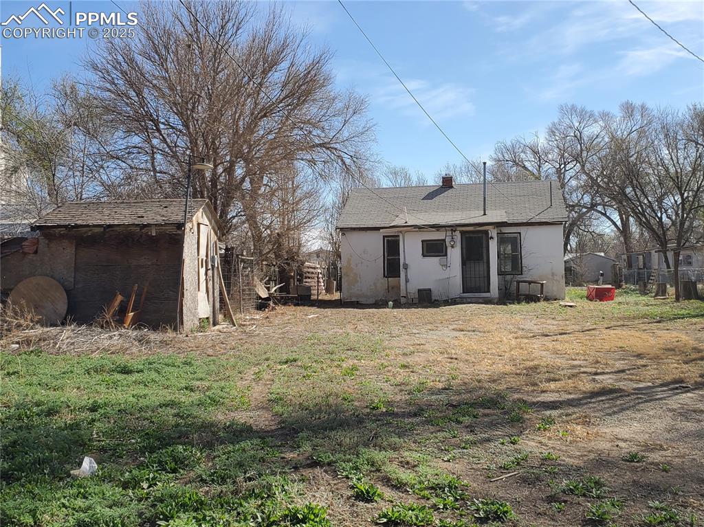 Image 25 of 28: Back Exterior & Backyard (Small, Old Shed to Left)