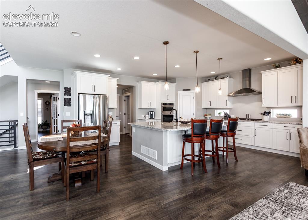 Image 12 of 50: Spacious kitchen featuring white cabinetry, stainless steel appliances, a l