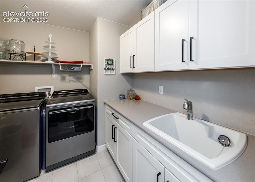 Image 21 of 50: White shaker cabinetry with matte black hardware, light-toned countertop, b