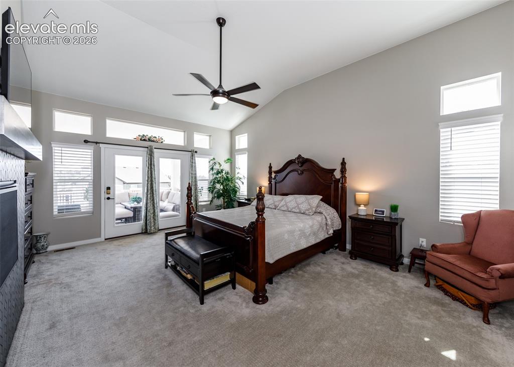 Image 22 of 50: Vaulted ceiling with a ceiling fan, French doors, transom windows, carpeted