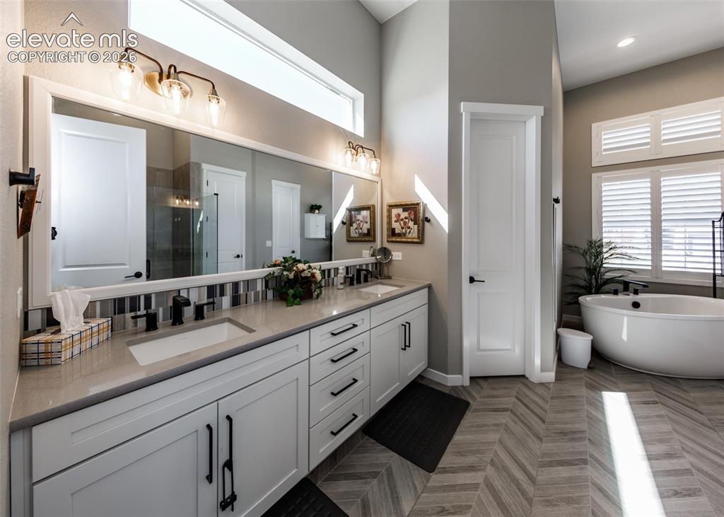 Image 25 of 50: Double vanity with undermount sinks and matte black fixtures, extensive cou