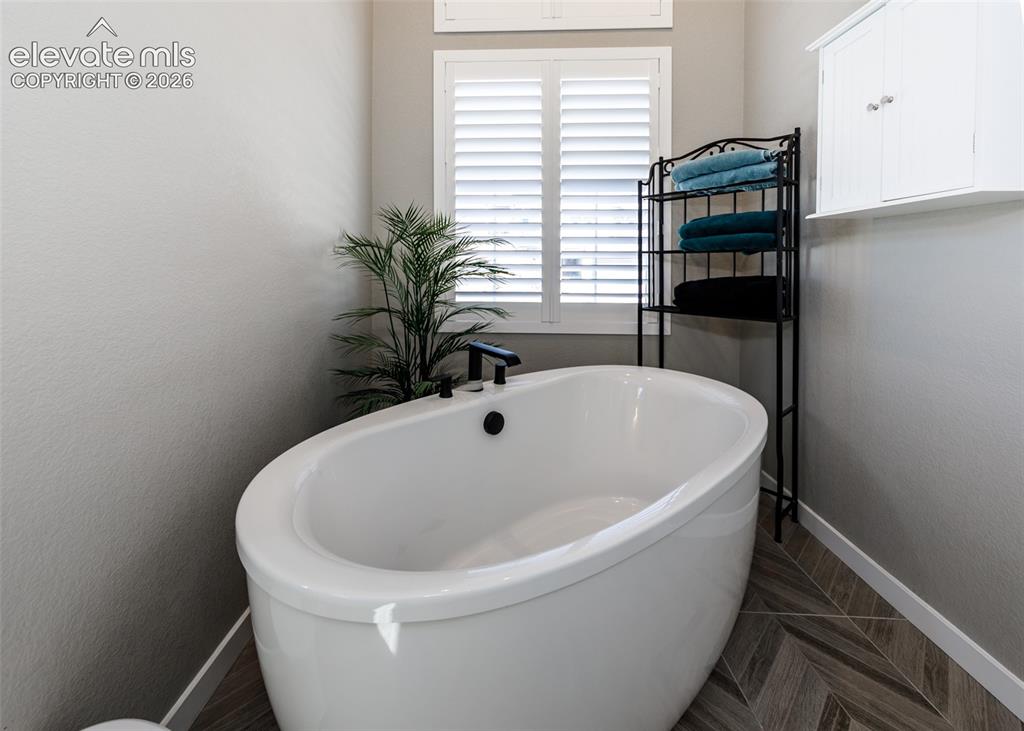 Image 26 of 50: Freestanding oval soaking tub with matte black fixtures