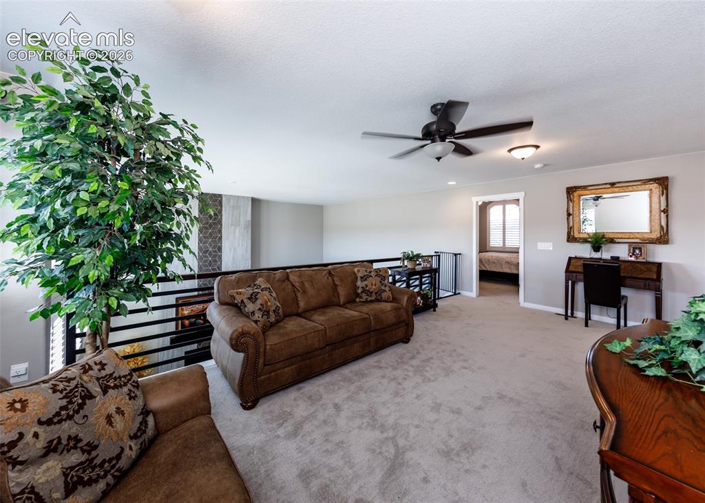Image 29 of 50: Carpeted loft space featuring a ceiling fan, recessed lighting, and a metal