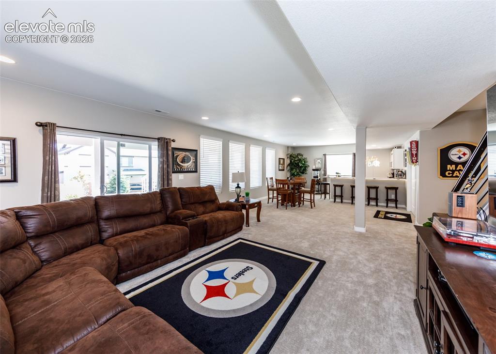 Image 34 of 50: Recessed lighting illuminates the open-concept living space with light-colo
