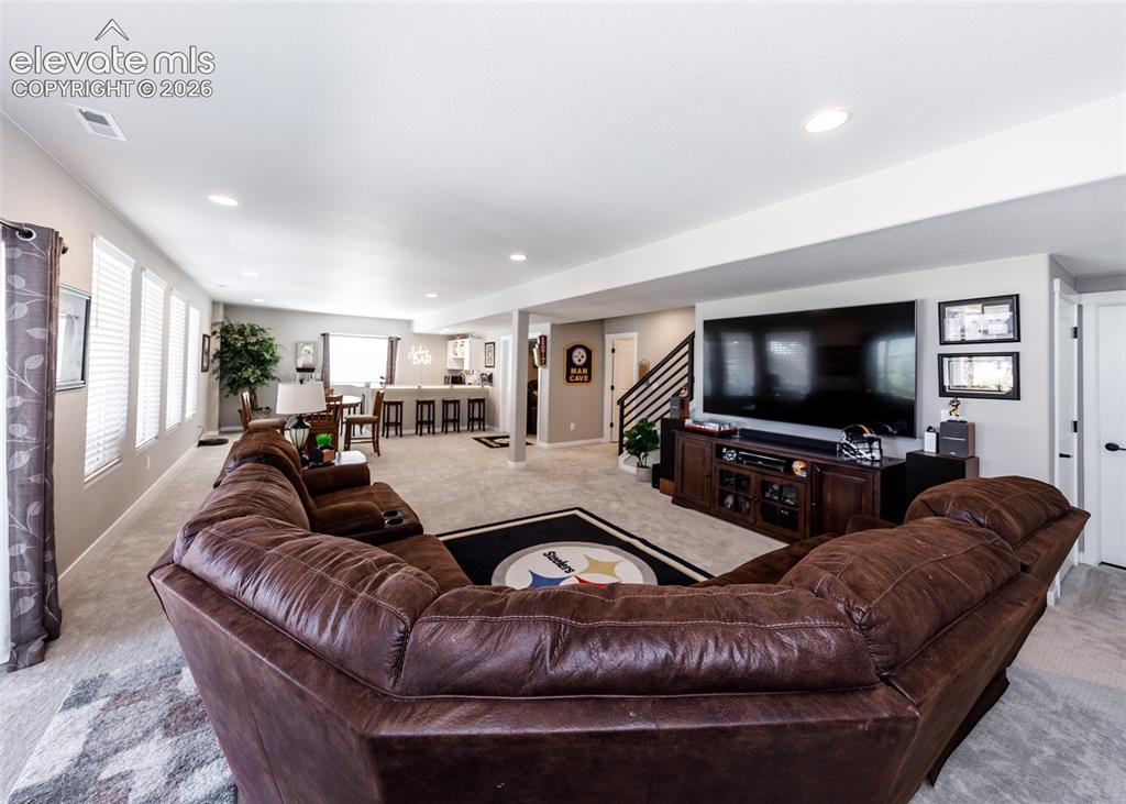 Image 35 of 50: Recessed lighting illuminates a spacious open-concept living area with carp