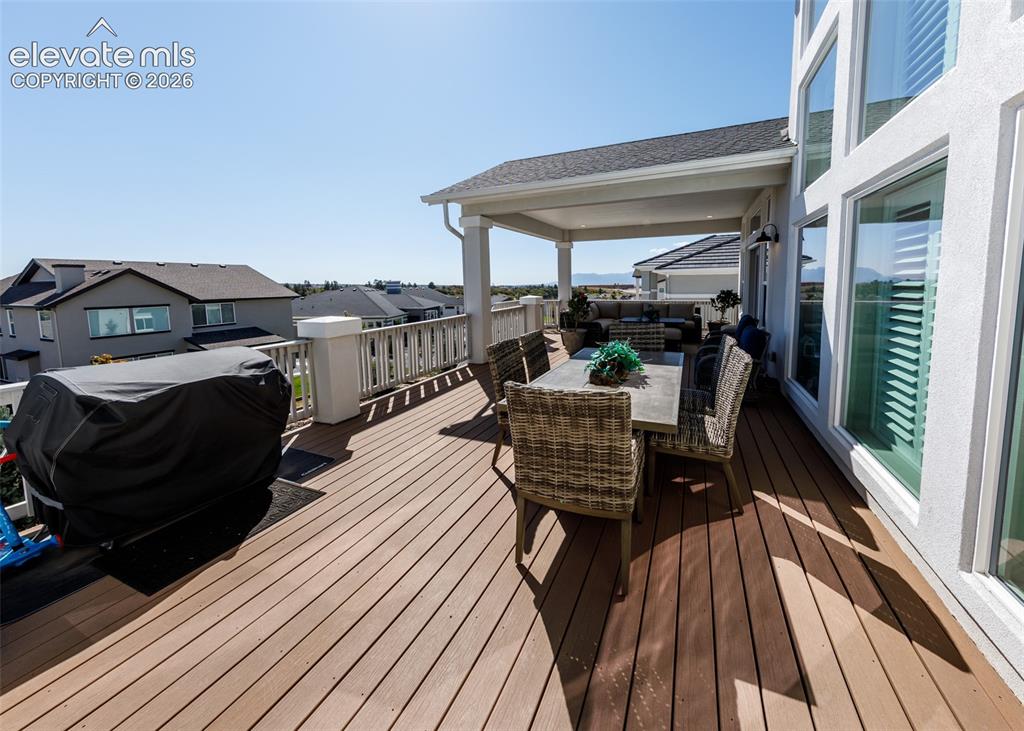Image 46 of 50: Expansive outdoor deck featuring wood-finish flooring, white railing, and a