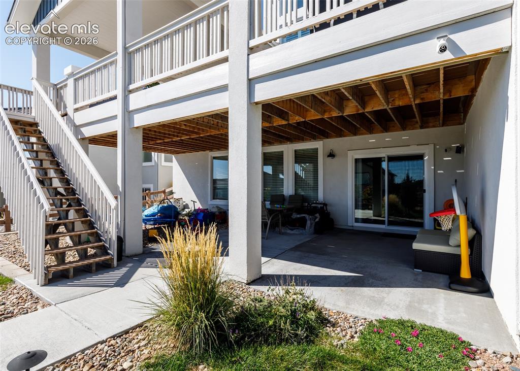 Image 48 of 50: Covered patio with a sliding glass door, a window, and an exterior wall lig