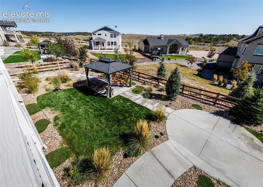 Image 50 of 50: Landscaped yard featuring a concrete patio, gravel beds, manicured lawn, an