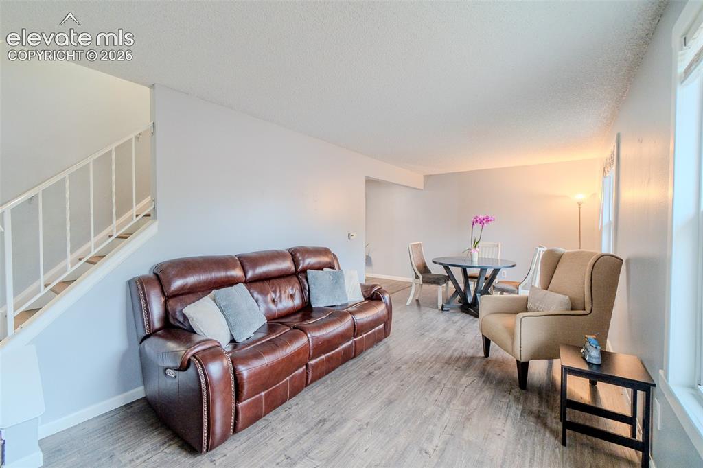 Image 14 of 33: Open-concept living area featuring wood-finish flooring, light gray wall to