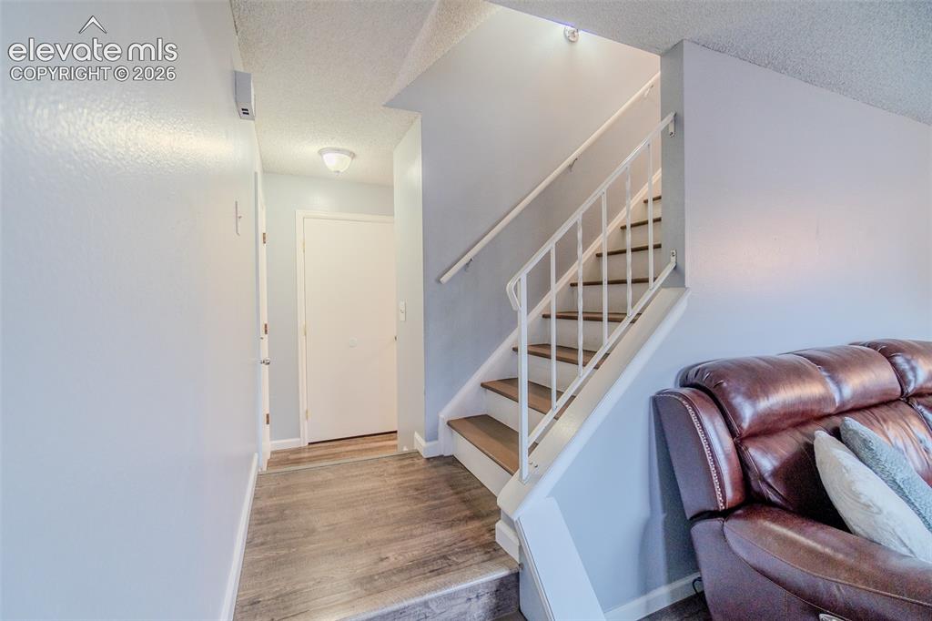 Image 15 of 33: Landing to go upstairs, garage to the left and bathroom straight ahead. 