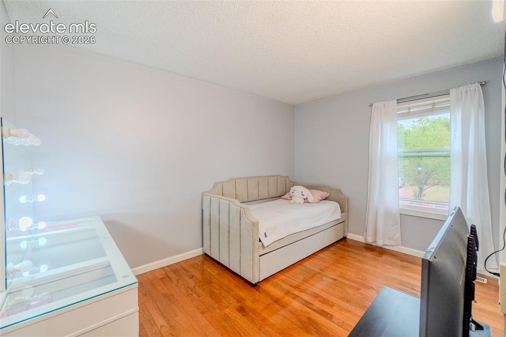 Image 16 of 33: One of three upstairs bedroom-filled room featuring wood-finish flooring an