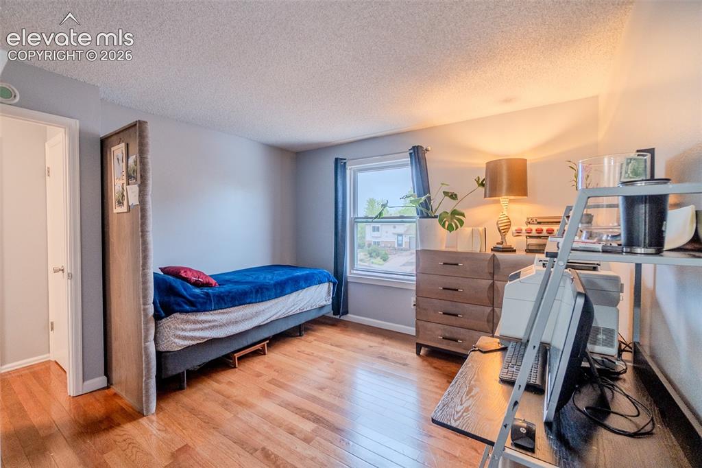Image 19 of 33: 2nd Bedroom upstairs with Hardwood-finish flooring, window with curtain rod