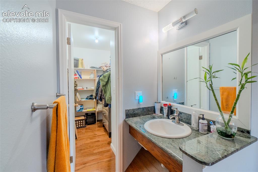 Image 20 of 33: In Second bedroom has a vanity featuring a polished granite countertop with
