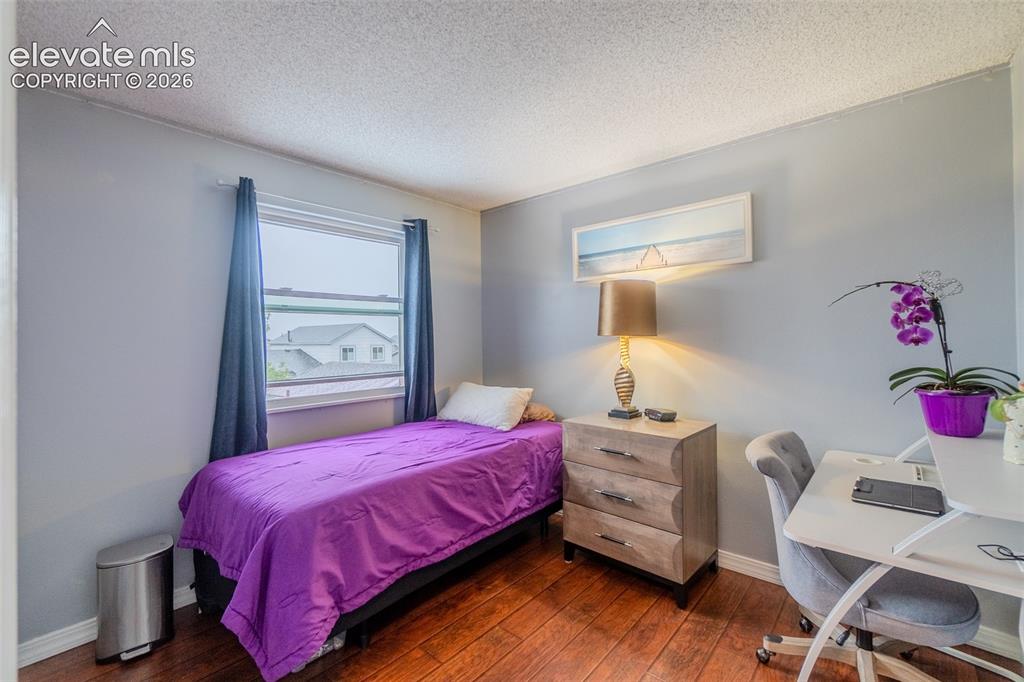Image 22 of 33: Third Upstairs bedroom featuring wood-finish flooring, light gray walls, a 