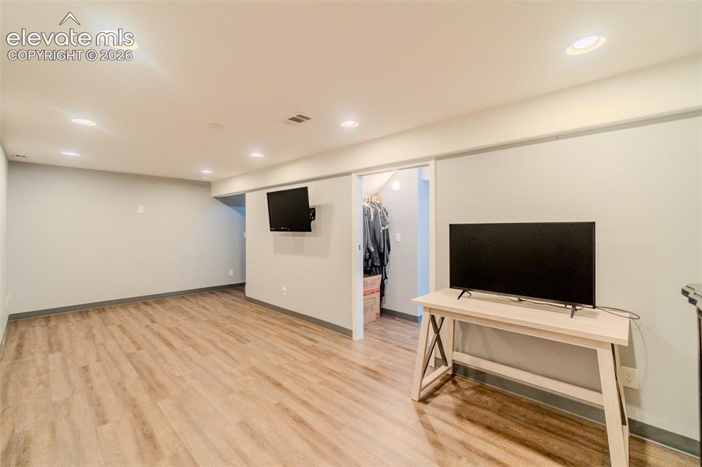 Image 24 of 33: Spacious living room basement featuring recessed lighting, light wood-finis