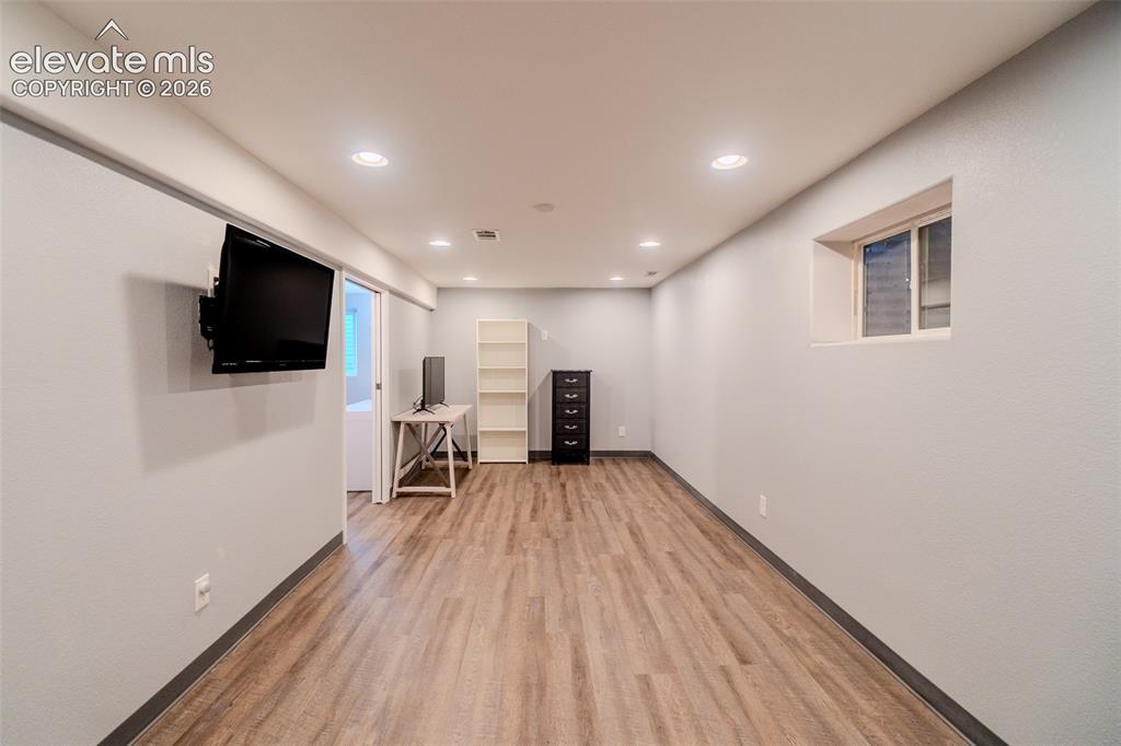Image 25 of 33: Mounted TV in basement living room with recessed lighting and prewired for 