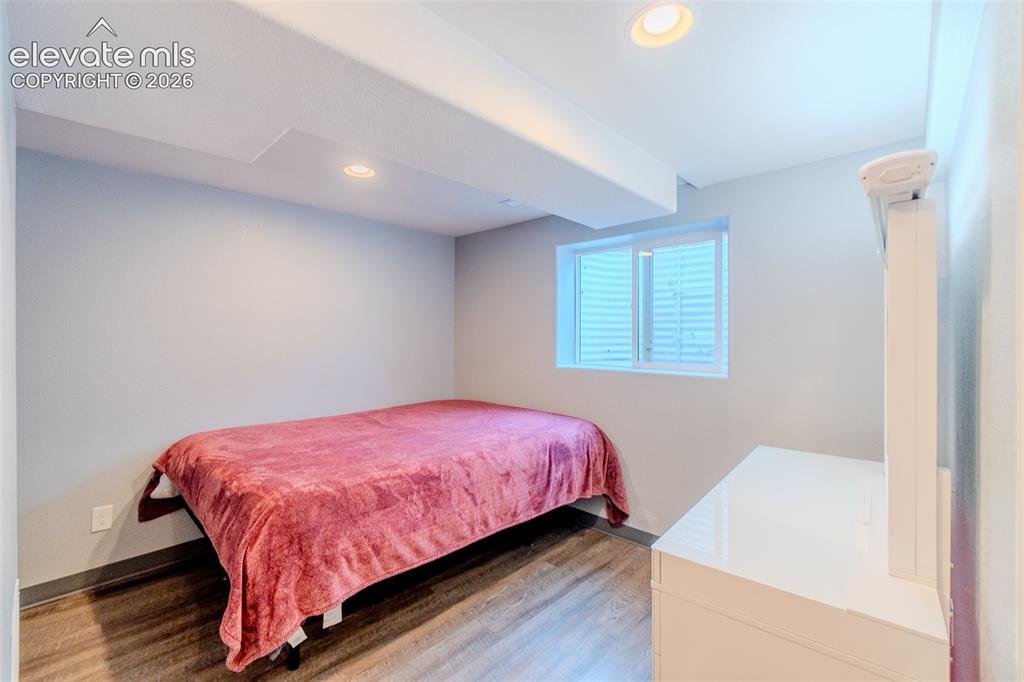 Image 26 of 33: Basement bedroom featuring wood-finish flooring, recessed lighting, and a w