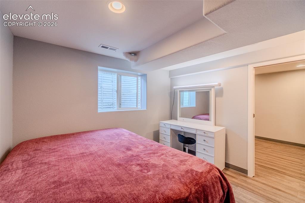 Image 27 of 33: Basement bedroom with pocket door to the living room 