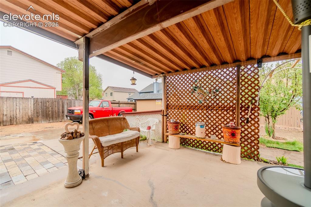 Image 31 of 33: Covered patio with a wood-finish ceiling, concrete flooring, and a decorati