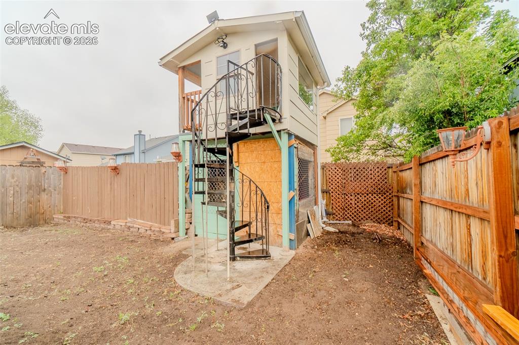 Image 4 of 33: Detached playhouse featuring a second-story balcony with wood railing, acce