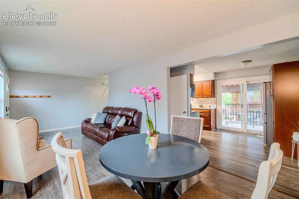 Image 7 of 33: Open-concept living area featuring wood-finish flooring, wide entryway into