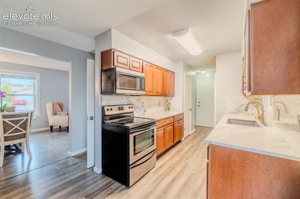 Image 9 of 33: Kitchen featuring wood cabinetry, light-toned countertops, a stainless stee