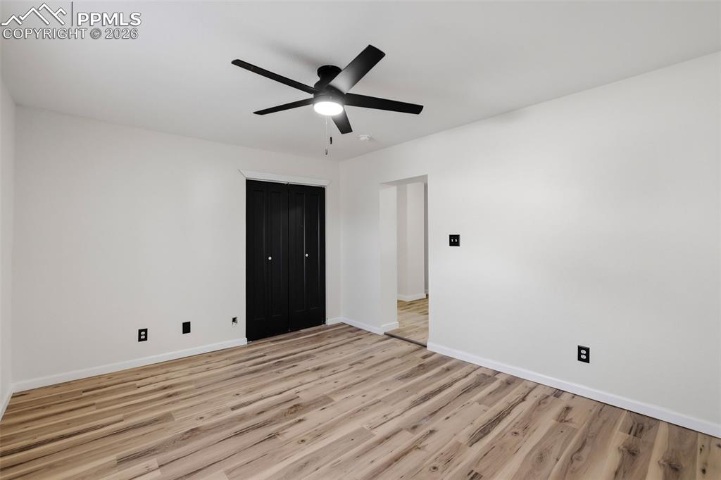 Image 16 of 36: Unfurnished bedroom with light wood-style flooring, ceiling fan, and a clos