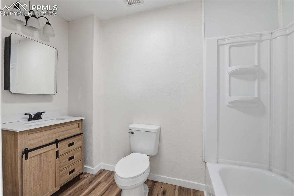 Image 20 of 36: Full bathroom with vanity, light wood finished floors, and shower / bath co