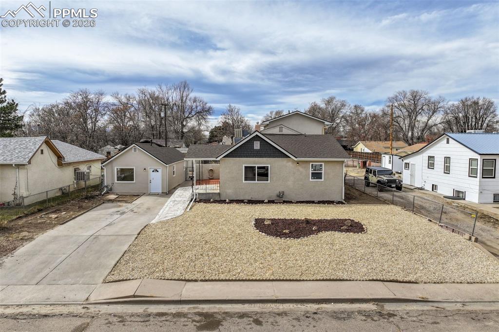 Image 3 of 36: Bungalow-style house featuring concrete driveway, stucco siding, a resident