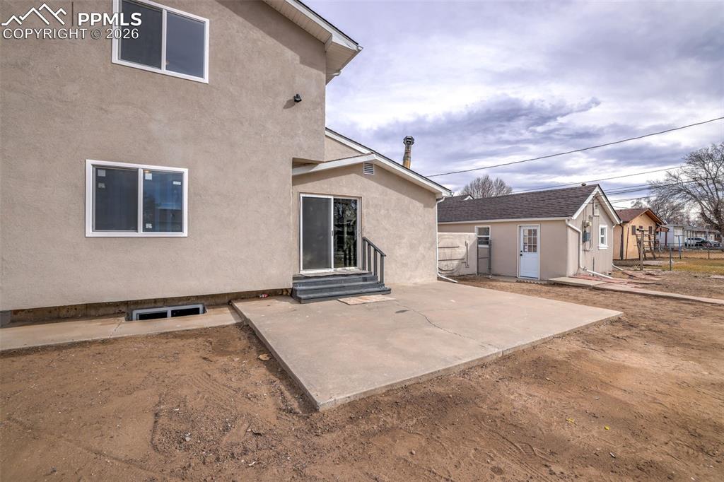 Image 33 of 36: Back of house featuring a patio, stucco siding, and entry steps