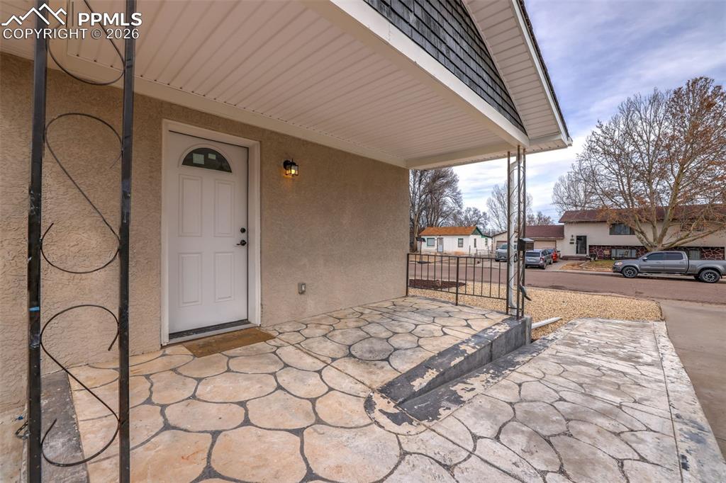 Image 5 of 36: Entrance to property featuring a porch and stucco siding