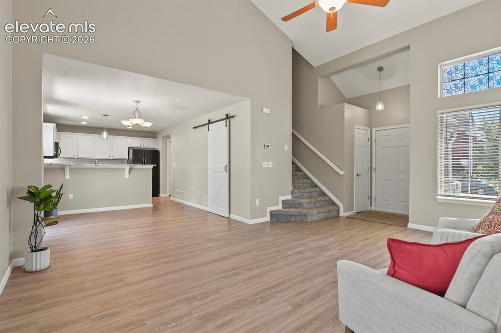 Image 10 of 46: Vaulted ceilings enhance the main living area featuring wood-finish floorin