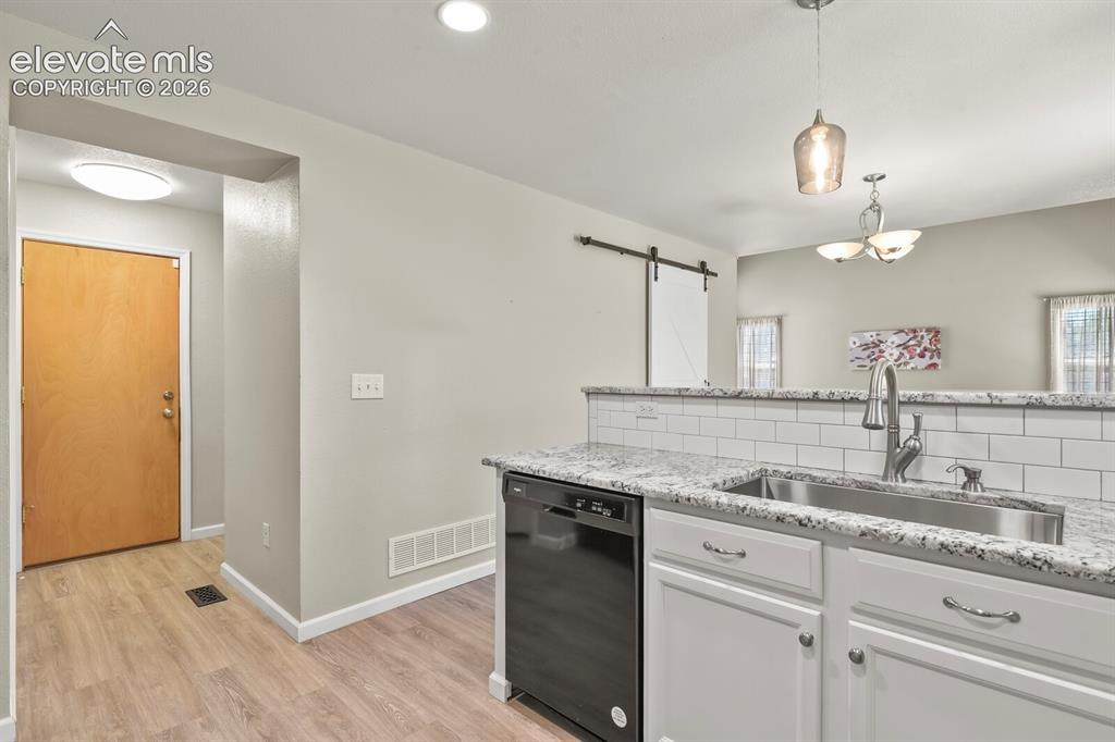 Image 14 of 46: Kitchen area featuring granite countertops, white subway tile backsplash, a