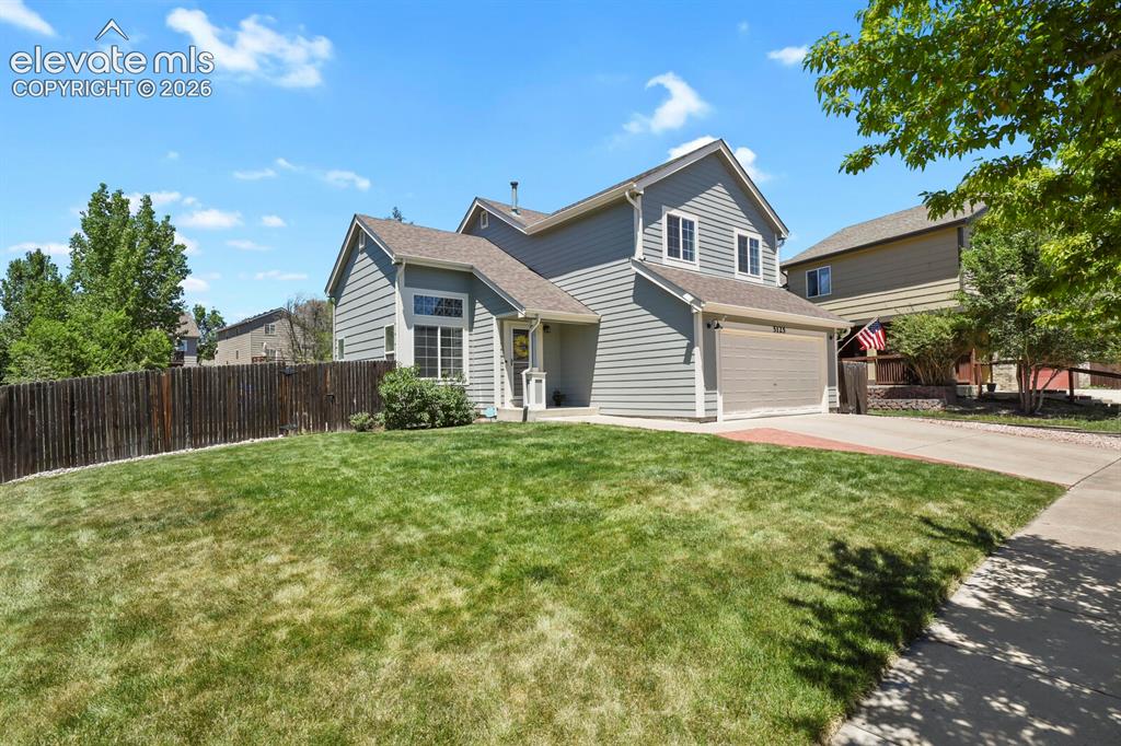 Image 2 of 46: Two-story residence featuring light gray siding and a two-car garage