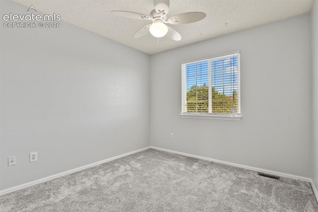Image 22 of 46: Bright room featuring a window with white blinds, neutral wall paint, and t
