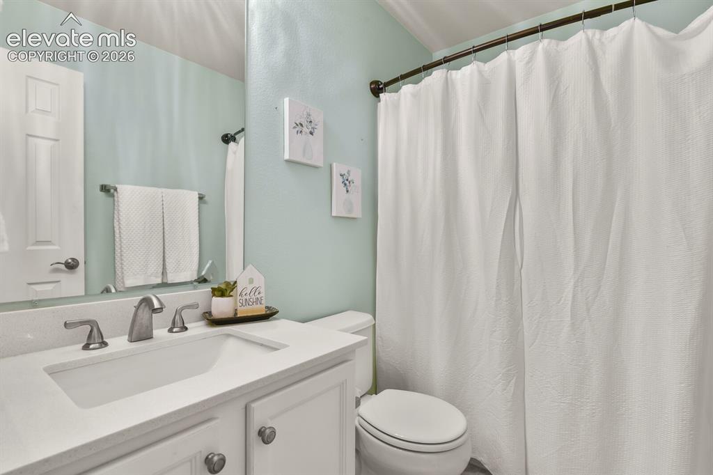 Image 24 of 46: Bathroom featuring a white vanity with an integrated sink, brushed nickel f