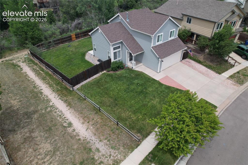 Image 39 of 46: Two-story residence featuring light blue siding and a dark shingle roof
