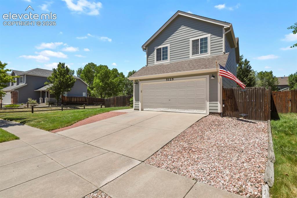 Image 4 of 46: Two-story siding exterior with an attached garage, concrete driveway, and g