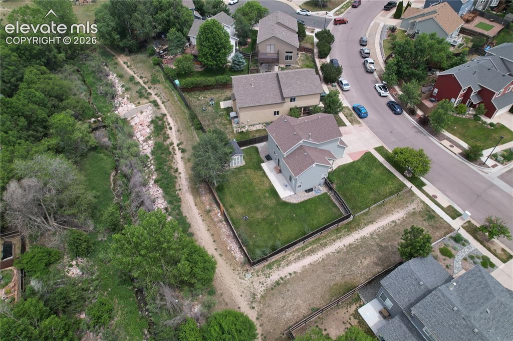 Image 40 of 46: Two-story residence with a gray exterior and brown roof shingles, featuring