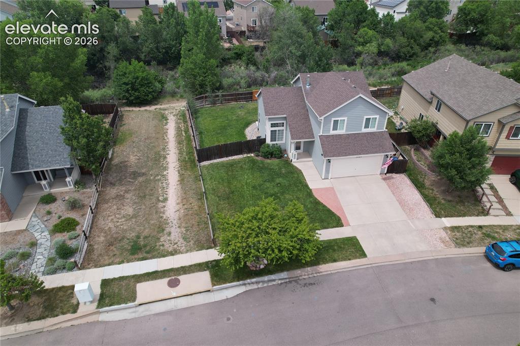 Image 42 of 46: Light blue two-story residence featuring a two-car garage, concrete drivewa