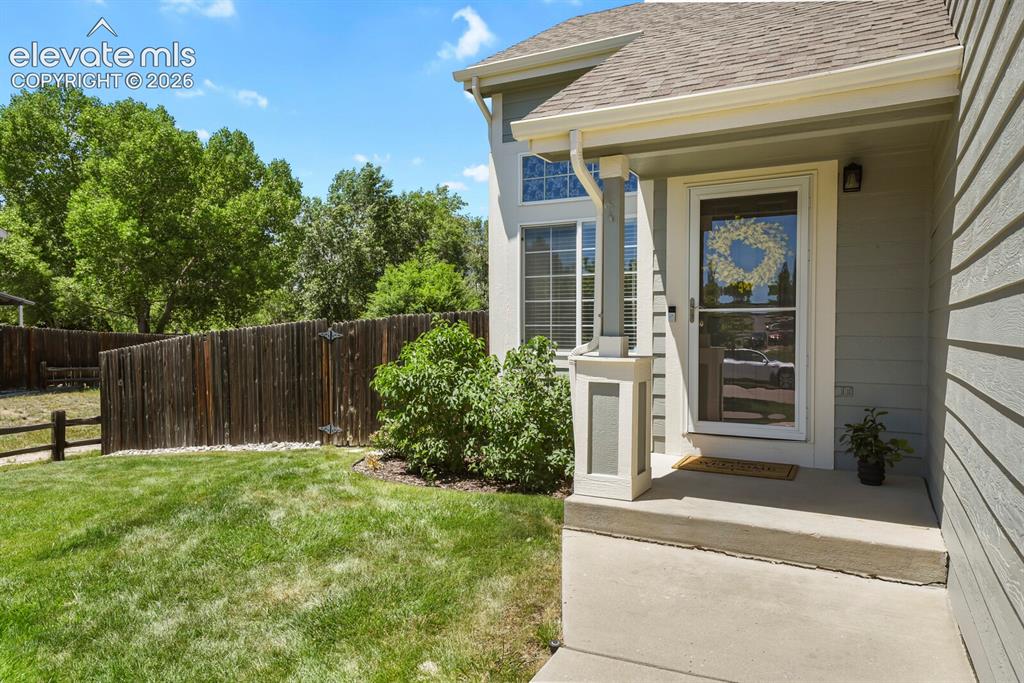 Image 5 of 46: Front entry featuring a storm door, an exterior wall light, and a concrete